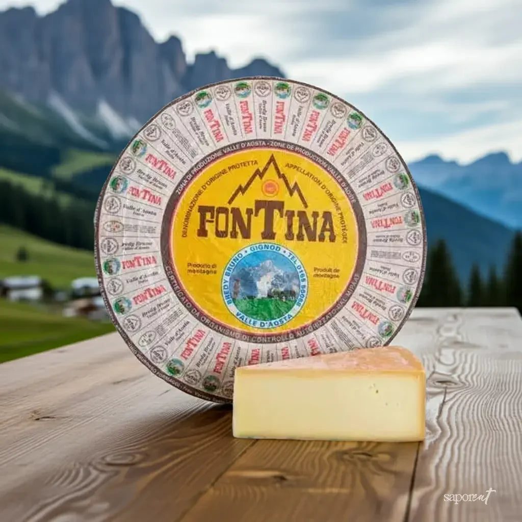 Wheel of Fontina Valle d'Aosta cheese with a wedge on wooden table, mountain landscape background