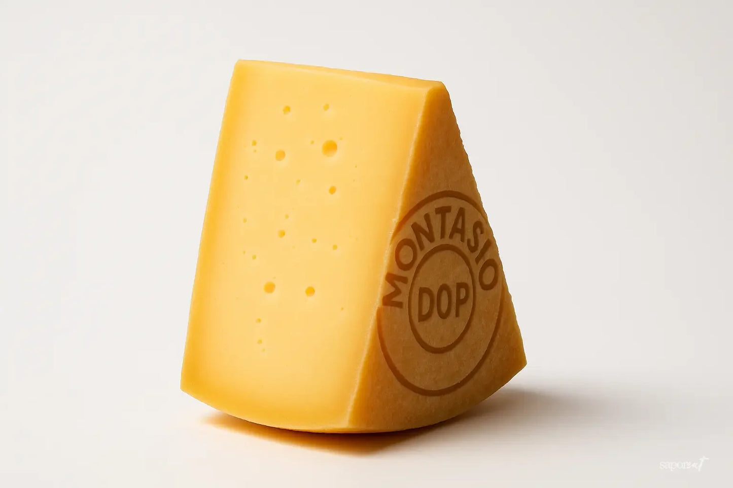 Wedge of Montasio PDO cheese with smooth texture and natural holes on white background