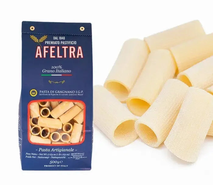 A 500g blue package of Afeltra rigatoni pasta made from 100% Italian durum wheat with rigatoni pasta pieces beside it