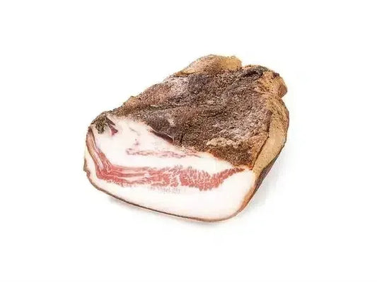 Piece of cured guanciale pork jowl with marbled fat and seasoned crust on white background