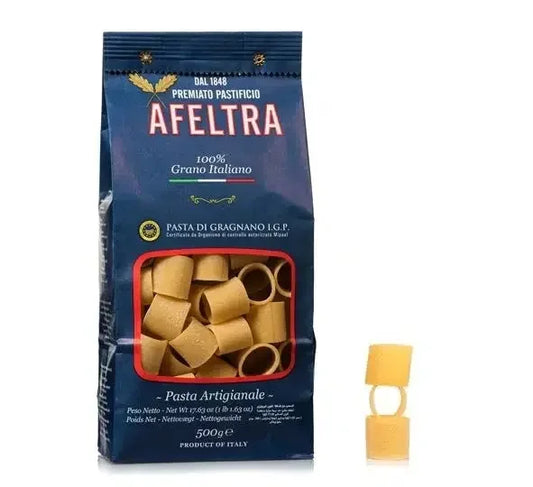 A bag of Afeltra Mezzo Pacchero premium Italian pasta tubes with two pasta pieces stacked beside it