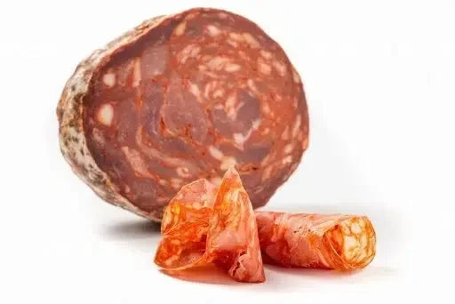 Slice of cured Ventricina salami with rolled thin slices on white background